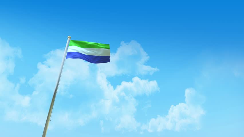 Sierra Leone Flag on Pole, Blue Sky and Clouds - Low Angle View