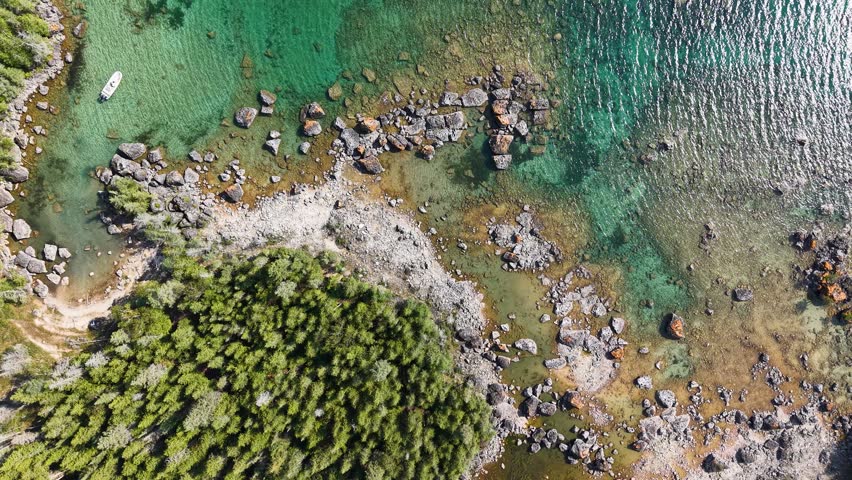 Aerial view of a lush wooded lagoon near Hessel, Michigan with clear blue water.