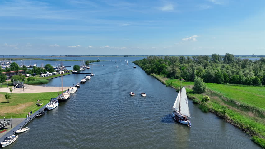 Aerial view of sailing boats navigating near the Galamadammen aqueduct in Friesland, Netherlands, Europe.