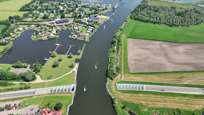 Aerial view of sailing boats navigating near the Galamadammen aqueduct in Friesland, Netherlands, Europe.