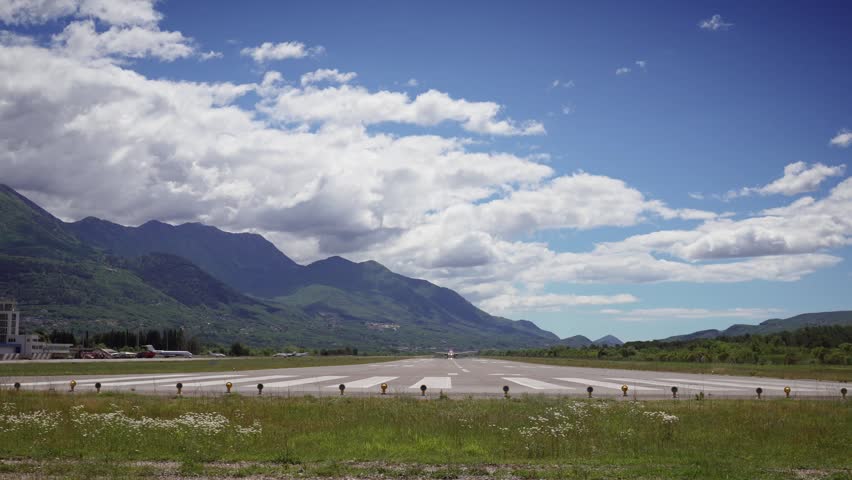Dramatic airplane takeoff from Tivat Airport in Montenegro, flying overhead against a clear blue sky, capturing the excitement of travel and aviation
