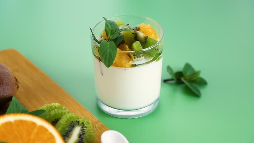 healthy breakfast yogurt with fresh kiwi and orange topping.