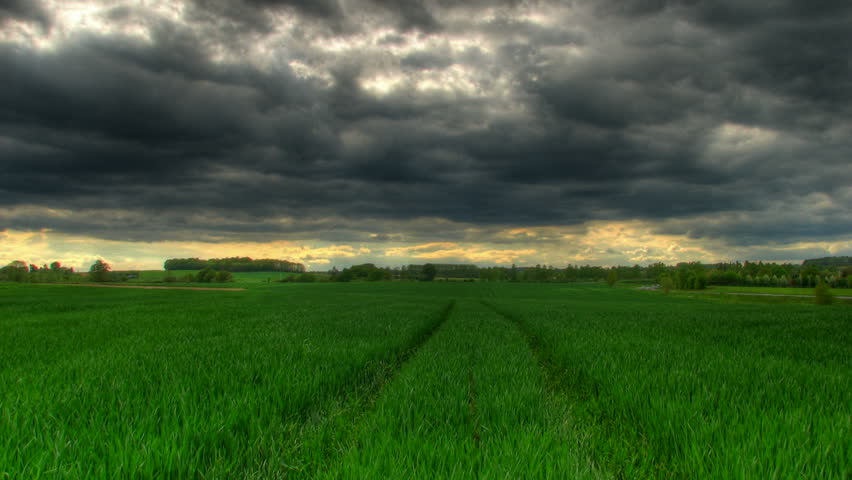 Storm clouds passing over green grass prairie, HD time lapse clip, high dynamic range imaging