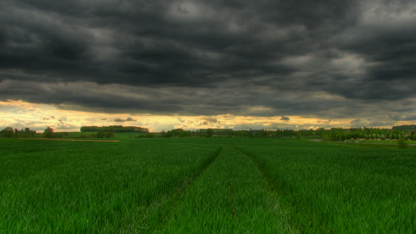 Storm clouds passing over green grass prairie, HD time lapse clip, high dynamic