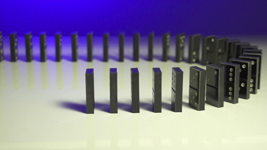 row of dominoes with one falling over on blue background