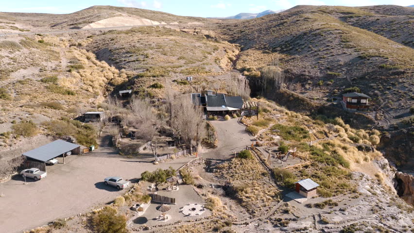 Main entrance of Turcará Aventuras eco-lodge nestled in the arid Malargüe badlands. Forward descending aerial approach.