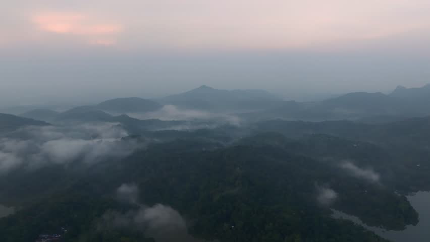 Aerial panorama of tropical lake covered in early morning fog