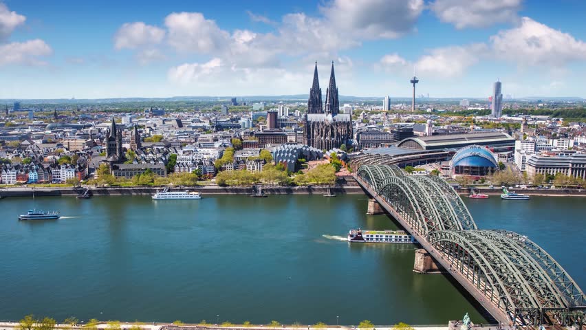 Elevated time lapse view of the cityscape of Cologne, Germany, with river Rhine, Cathedral and old town houses at the riverfront during a sunny summer day