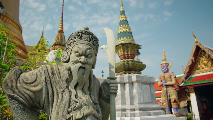 Stone guardian warrior statue at Wat Phra Kaew in Bangkok, traditional Thai temple architecture and mythology landmark