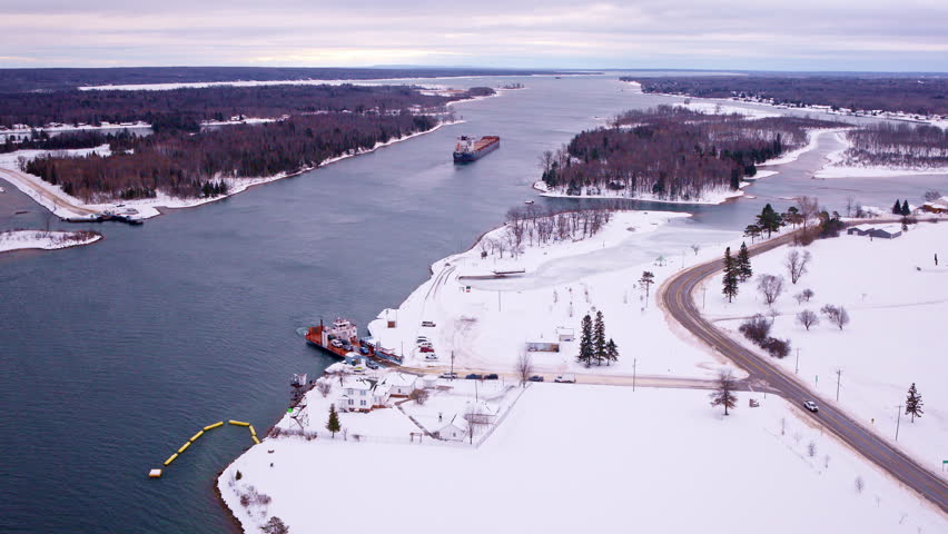 Drone shot of a commercial ship navigating the St. Marys River toward Sault Ste. Marie