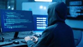 Back view of mysterious hooded hacker typing computer code on a keyboard in a dark room with multiple monitors, symbolizing cybercrime, cybersecurity threats, data breach, and software program. - Powered by Shutterstock - Get 15% off with code: PIKWIZARD15