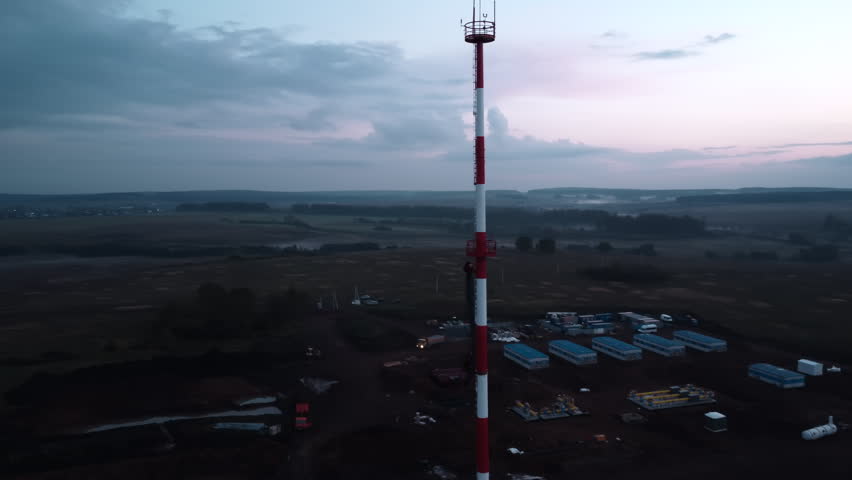 Aerial view of a communications tower above rural fields at dusk