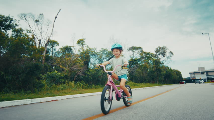 Pre teen girl learns cycling on the safety city area with no traffic and enjoys the bicycle riding