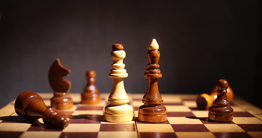 Wooden chess pieces on a dark board, close-up