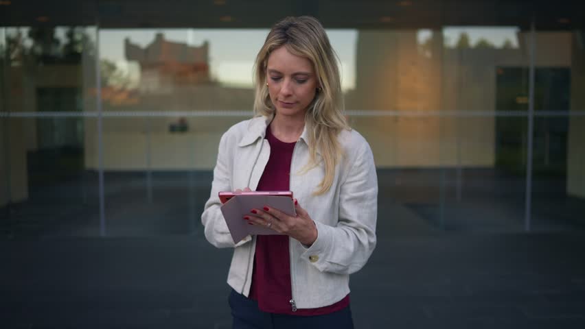 Businesswoman using a digital tablet smiling at the camera