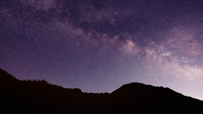 Night landscape. The hill silhouette under bright colorful milky way galaxy. Space, night scene time lapse.