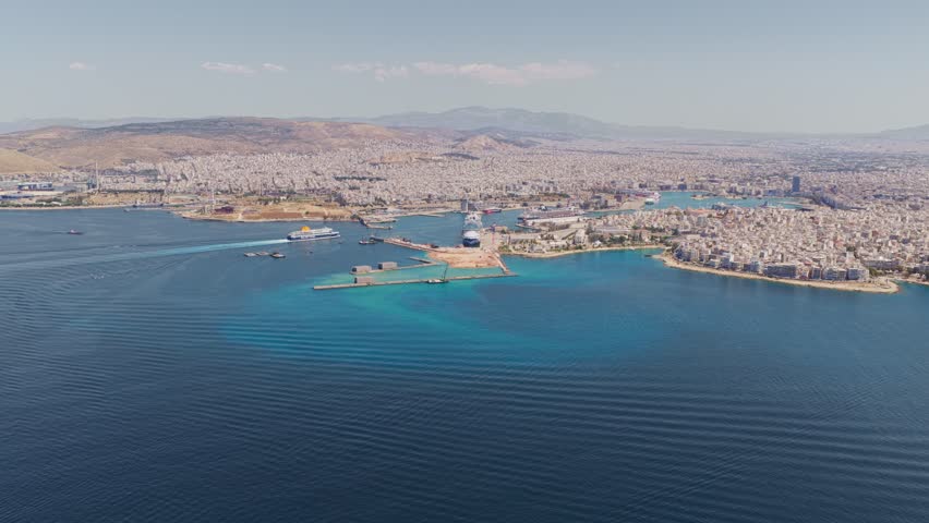 Sunny aerial panorama of the bustling port of piraeus, showcasing the dense cityscape of athens, greece, with ferries and cruise ships navigating the clear blue mediterranean waters