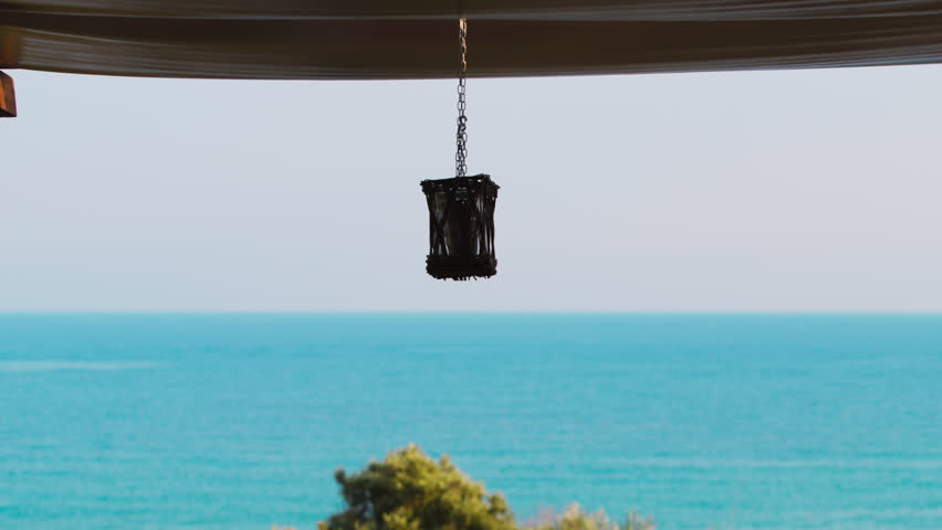 Lantern on the terrace of a hotel overlooking the blue Mediterranean in Sicily