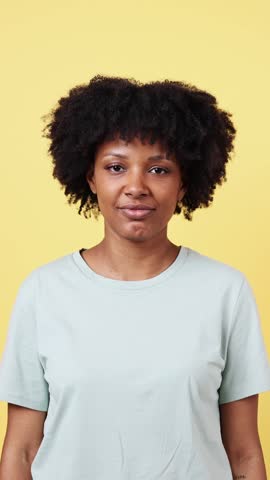 Playful woman expressing different emotions on yellow background