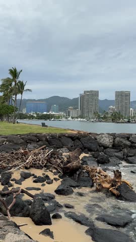 Vertical view of the scenic Waikiki beach coastline, tropical ocean waves, and luxury seaside resorts under a bright sky, Honolulu, Oahu, Hawaii.