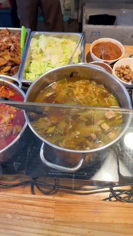 A high-angle camera pans across various colorful Thai curries and fried dishes at a market