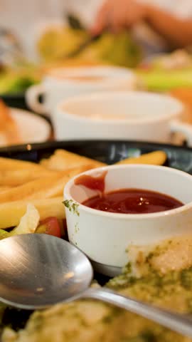 A close-up shot of french fries, ketchup, and salad served on a restaurant dining table