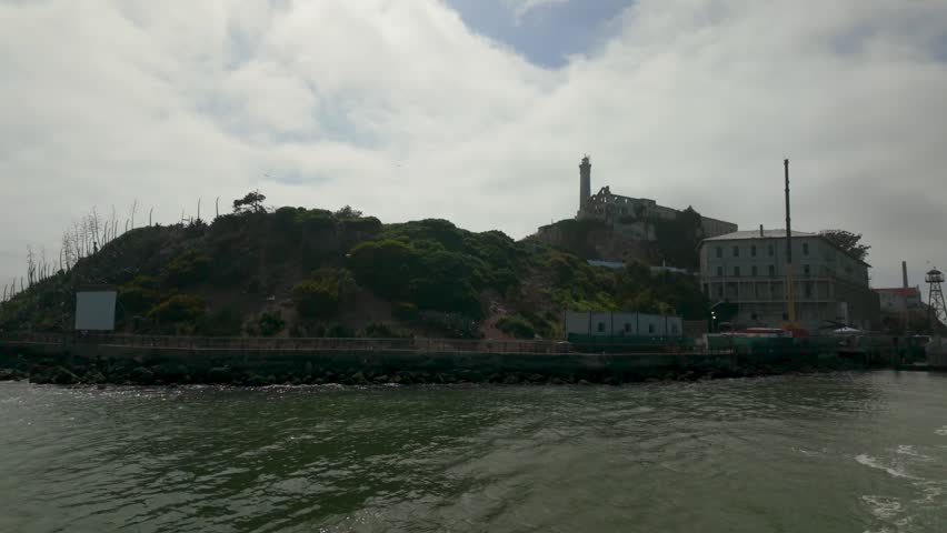 Sailing away from Alcatraz Island, the prison fades into fog and distance behind the boat. San Francisco skyline grows closer as wind fills the sails. Tourists look back at the rocky cellhouse, carrying stories of escape and isolation home.