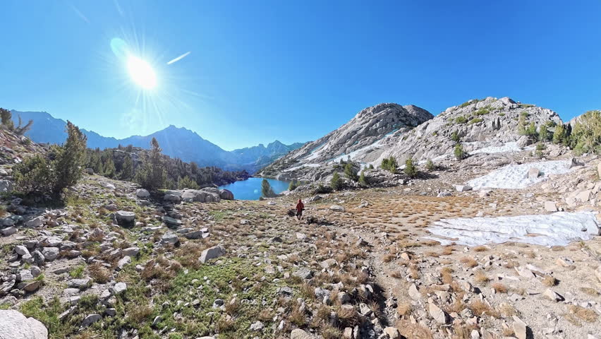 Following Man Hiking Down to Alpine Lake in the Sierras of King Canyon National Park
