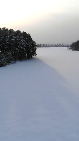 Dawn Warms Icy Landscape. Early Morning Sun Illuminates Snowcovered Lake Surrounded By Tall Pine Trees. Media