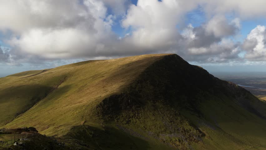 Mountain landscape with moving clouds shadowing the ground