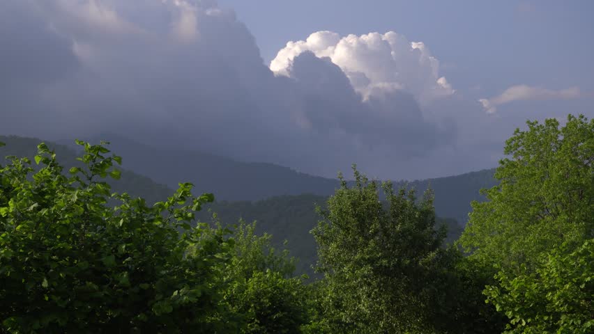 Dramatic sunset scenery with mountains view before heavy rain in village area.