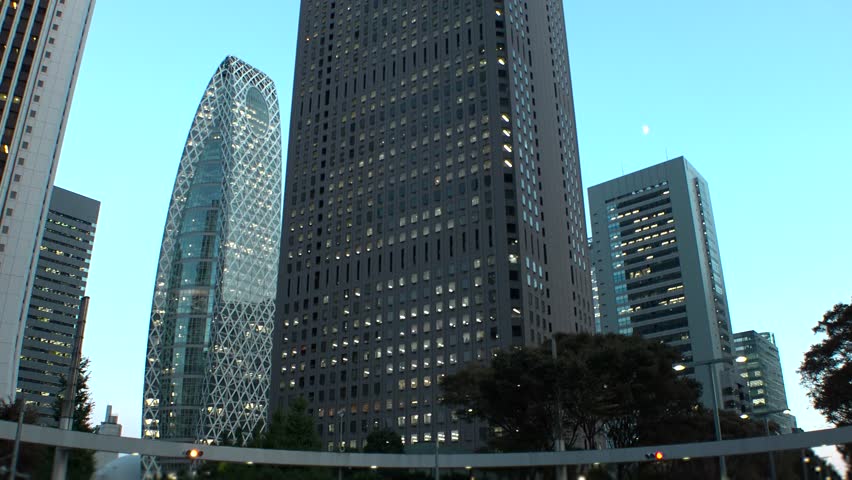 SHINJUKU, TOKYO, JAPAN - JULY 2025 : Cityscape of Tokyo at night, featuring a vibrant business district and towering office buildings. A dynamic and modern urban metropolis scene. Time lapse shot.