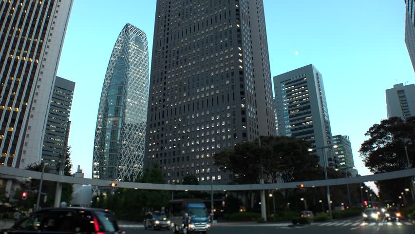 SHINJUKU, TOKYO, JAPAN - JULY 2025 : Cityscape of Tokyo at night, featuring a vibrant business district and towering office buildings. A dynamic and modern urban metropolis scene. Time lapse shot.