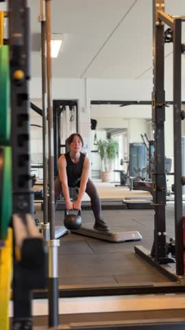 Female person trains her leg muscles inside a fitness weight rack station.
