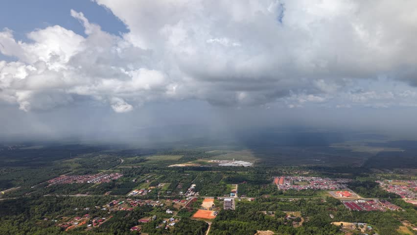 Dense clouds loom over green countryside outdoor