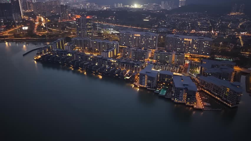 Drone aerial of waterfront residential complex at dusk in Penang, Malaysia.