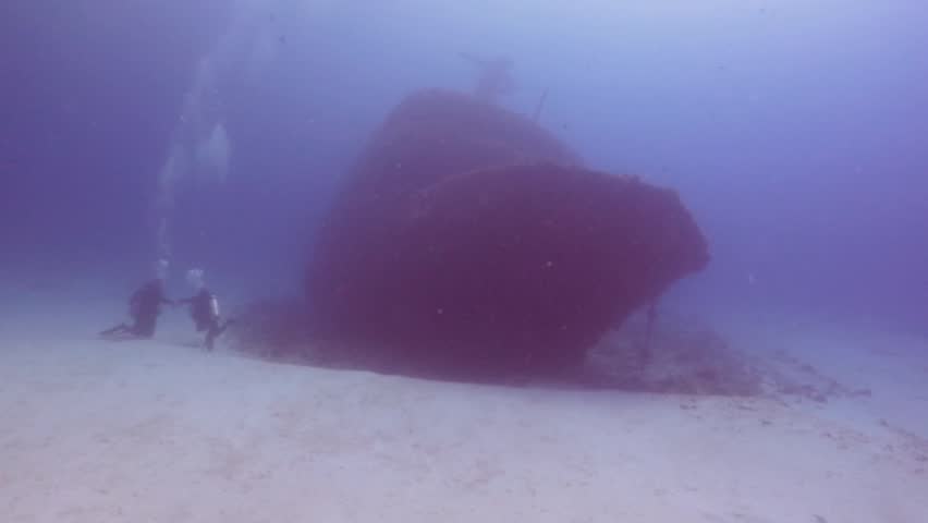 a couple of divers nexto a shipwreck