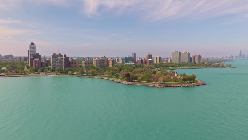 Panoramic view of the Chicago skyline with Promontory Point peninsula extending into Lake Michigan in the foreground