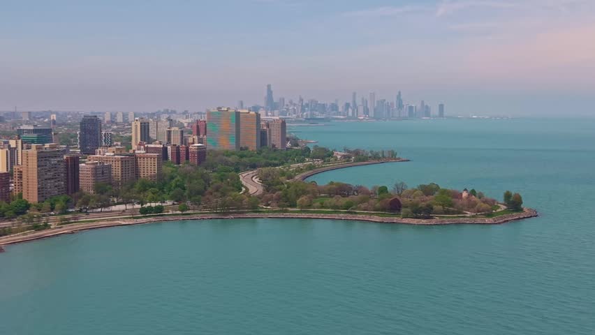 Panoramic view of the Chicago skyline with Promontory Point peninsula extending into Lake Michigan in the foreground