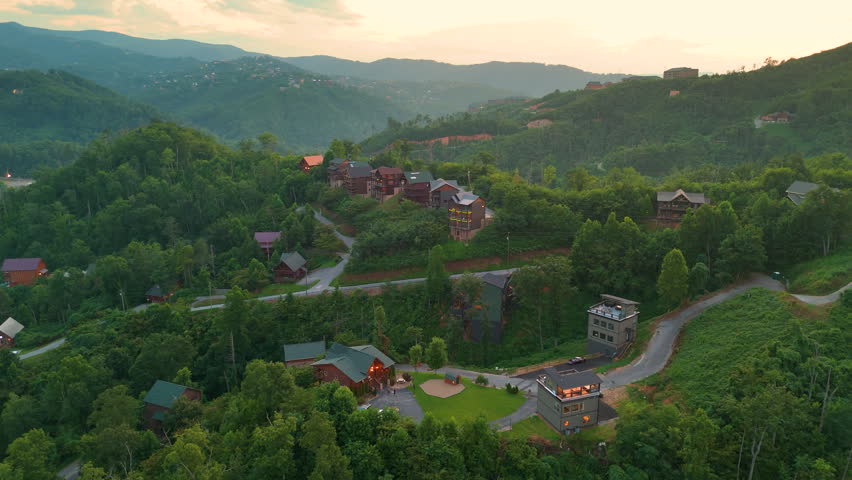 Aerial view of luxury mountain homes surrounded by lush forest and rolling hills in the Smoky Mountains in colorful summer
