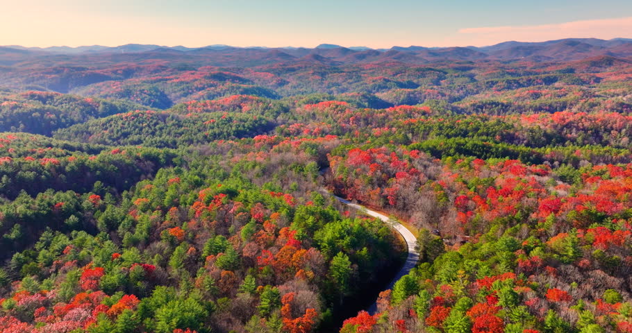 Golden autumn landscape in Appalachian mountains of North Carolina. Forest road winds through hills with vibrant fall foliage