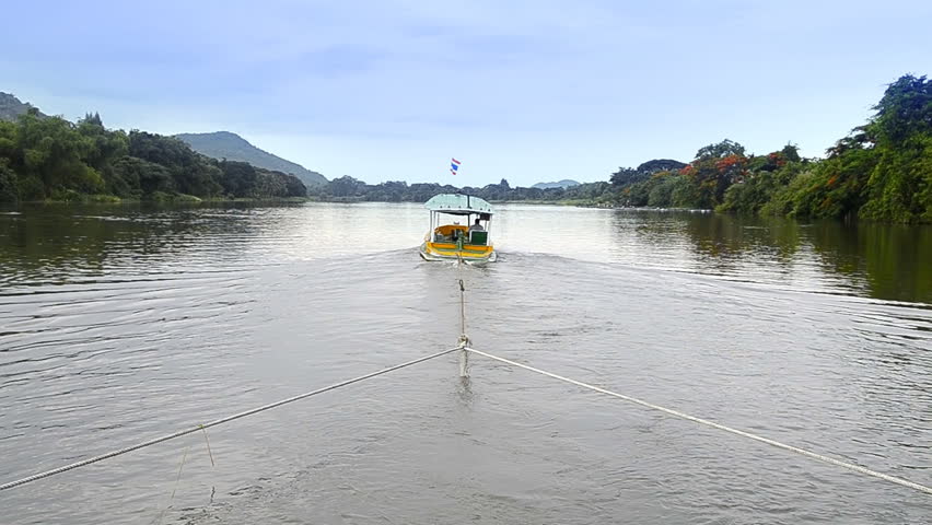 small boat drag houseboat with rope in river for travel of thailand