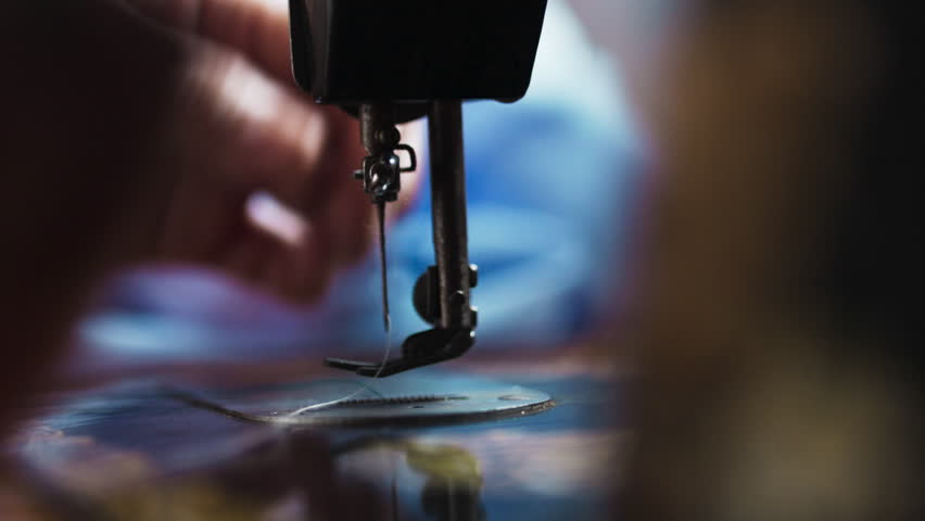 Close-up of Hands Operating a Vintage Sewing Machine Needle and Presser Foot	