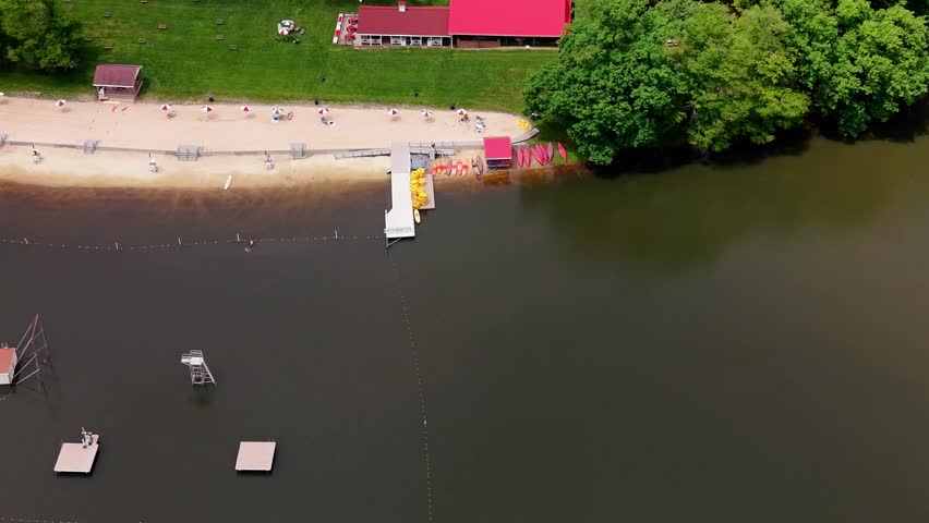 Drone shot of visitors swimming and relaxing by the water at the historic Mount Gretna Lake and Beach recreation area in Pennsylvania.