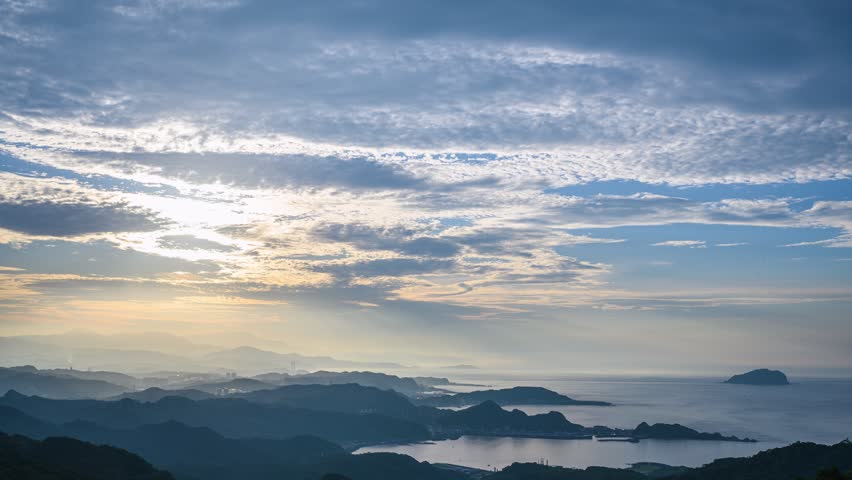 A breathtaking sunset view over the mountainous landscape and coastal scenery of Jiufen, New Taipei City, Taiwan, with golden light over the sea.