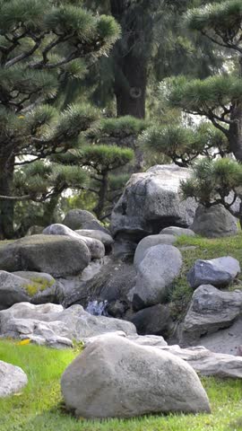 Close up of small waterfall flowing over rocks vertically