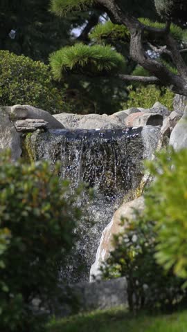 Close up of small waterfall flowing over rocks vertically