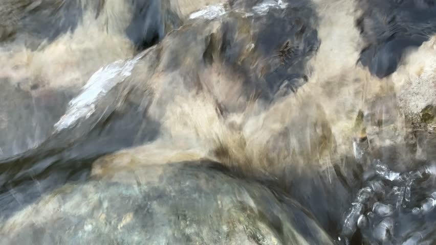 Close-up view of clear freshwater flowing rapidly over pebbles and stones in a mountain stream in Kashmir, India. Detailed water movement, ripples, and natural textures create a peaceful nature scene ideal for environmental, ecology, and outdoor concepts.
