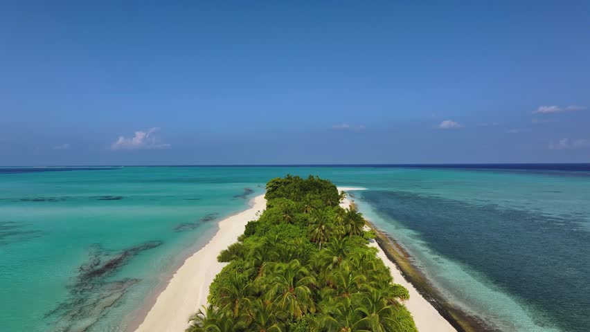 Aerial view of a tropical island with white sand beaches and lush palm trees surrounded by turquoise ocean water in Fulhadhoo, Baa Atoll, Maldives.