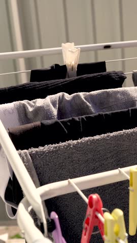 Clothes and linens are dried on a clothesline with clothespins on the balcony of the house, outside in the fresh air, in the sun